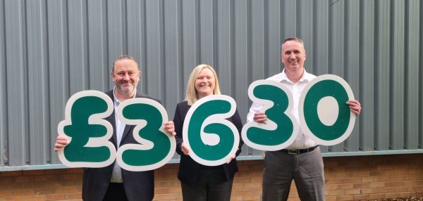Representatives from the UKGSA and Macmillan Cancer holding £3630 in figures